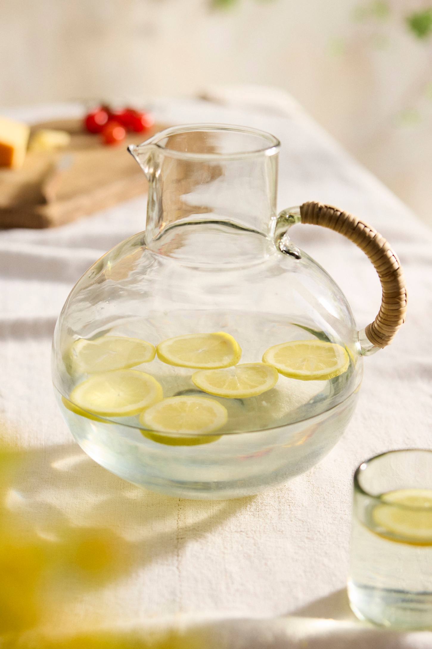 xenapaz-79.jpg Cane Handle Glass Carafe – Hand-Crafted Round Glass Pitcher with Natural Woven Handle - Image 1